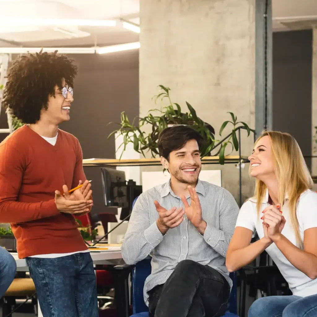 Arbeitskollegen lachen zusammen im Büro.